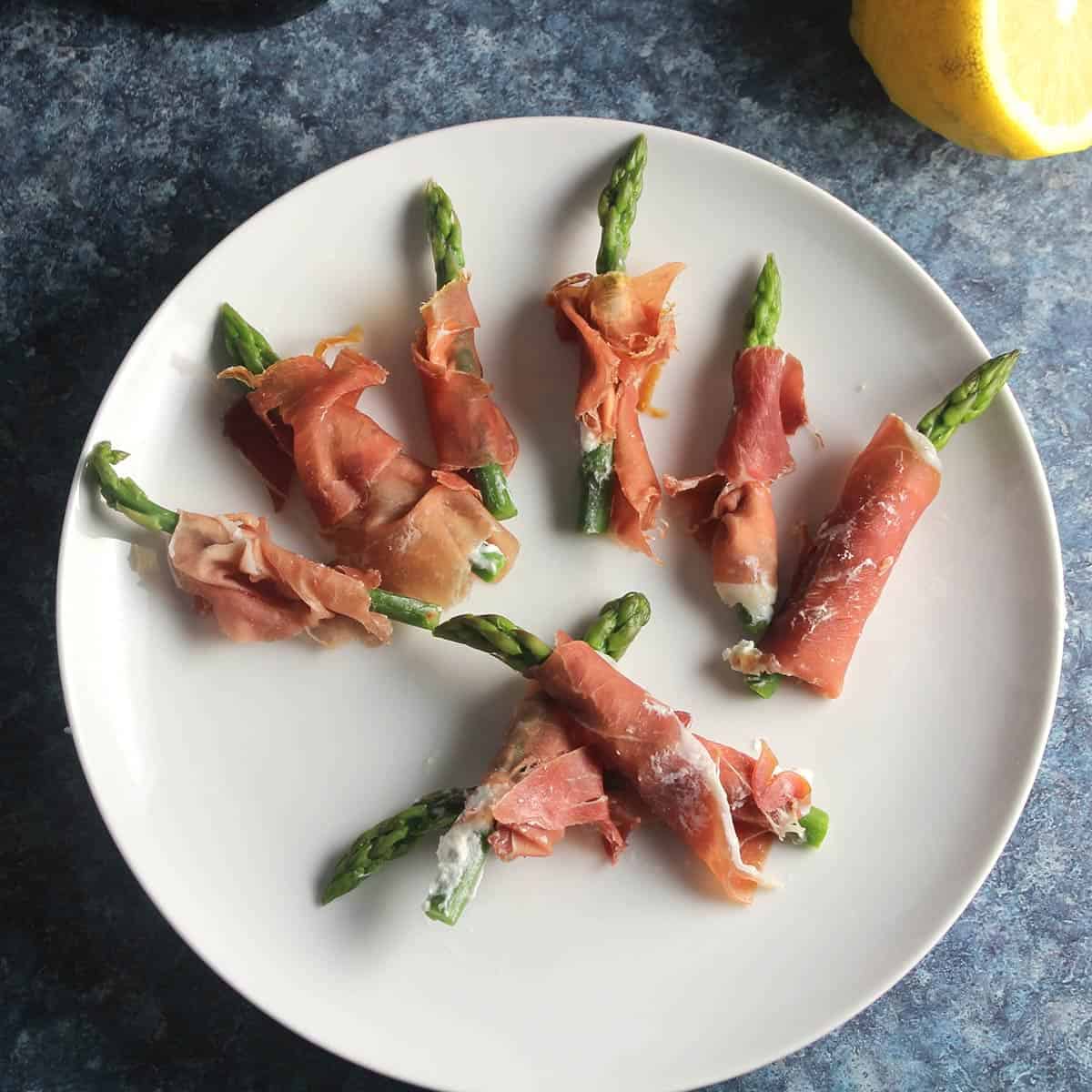prosciutto asparagus with goat cheese on a plate.