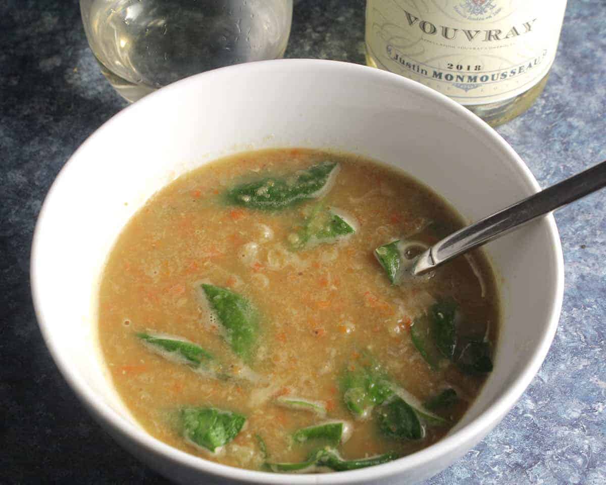 bowl of red lentil soup with spinach, served with white wine from Vouvray.