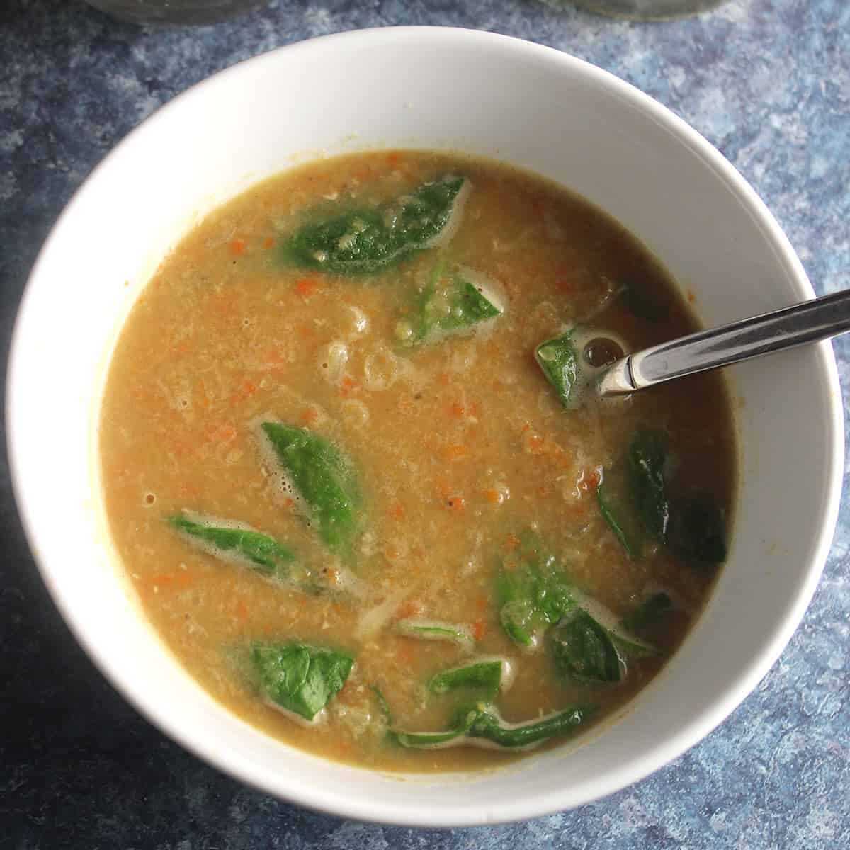 bowl of spicy lentil soup with spinach.