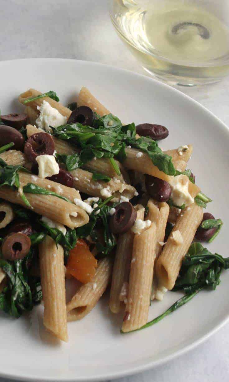 penne with arugula, garlic and beans on a plate.