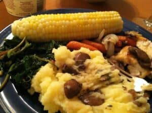 callalloo side dish served with mashed potatoes, corn and chicken