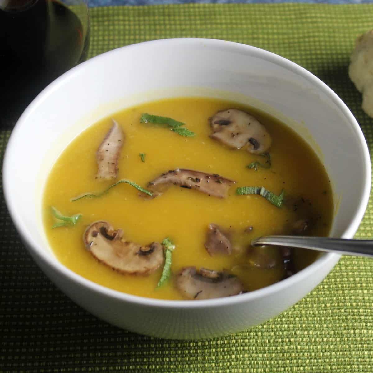 white bowl with butternut squash soup topped with mushrooms