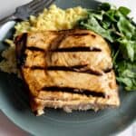 grilled swordfish plated with rice pilaf and green salad.