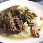 braised short ribs with mushrooms, served over potatoes.
