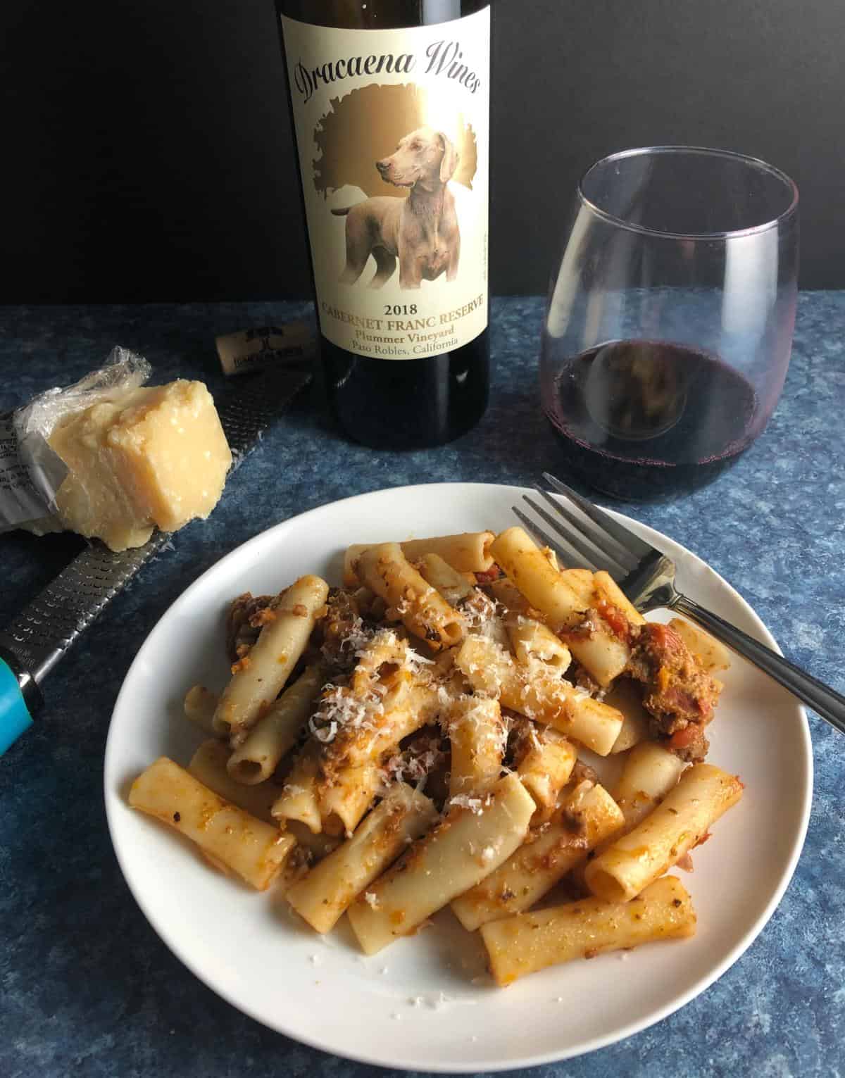 plate of bolognese pasta served with a bottle of Cabernet Franc.