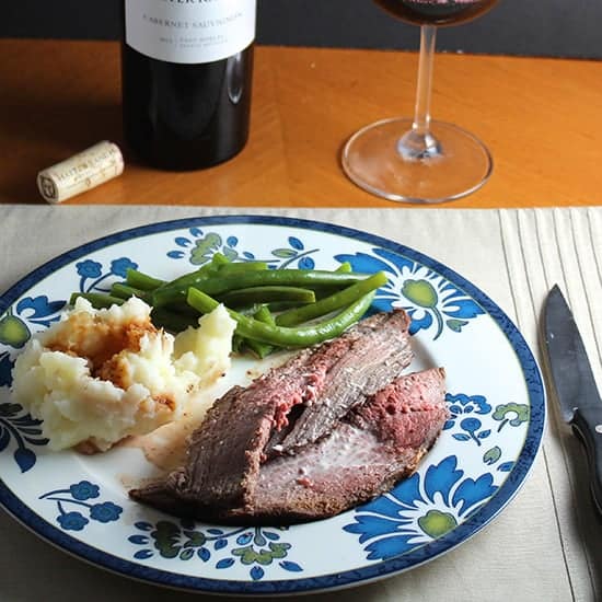 spoon roast beef topped with a horseradish sauce served with mashed potatoes, on a flowered plate