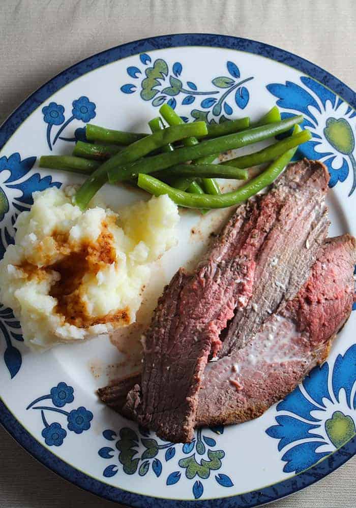 spoon roast with horseradish cream, plated with potatoes and green beans.