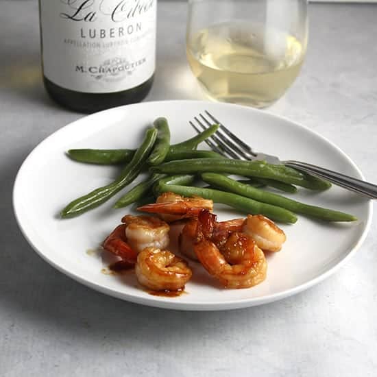 white Rhone wine served with a plate of sautéed shrimp.