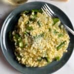 pea and asparagus risotto on a gray plate.