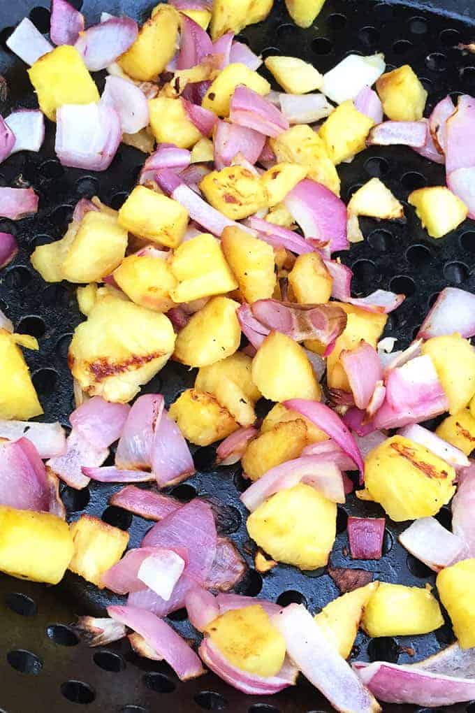 grilling pineapple and onions in a grill pan.