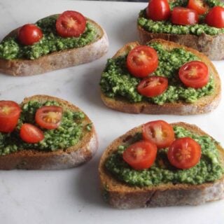 crostini topped with pesto and red tomatoes