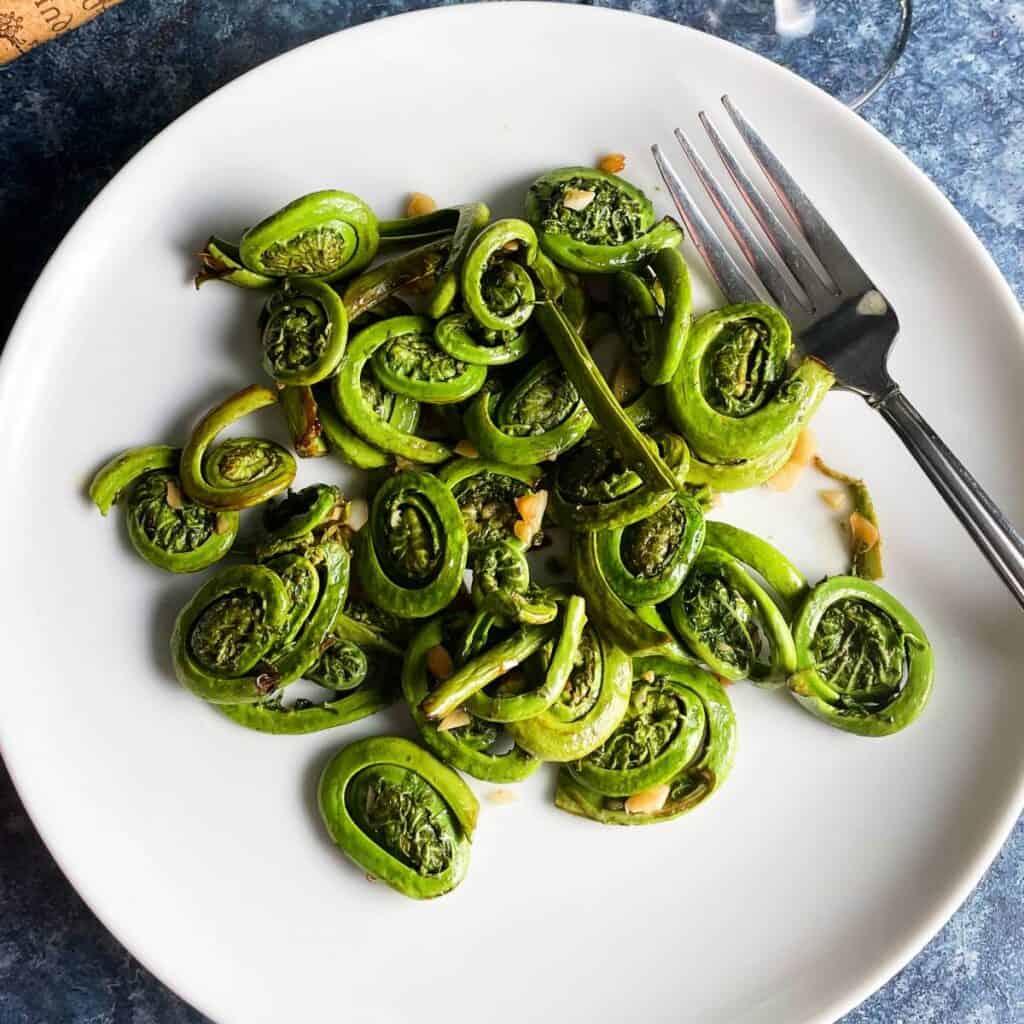 sautéed fiddlehead ferns on a white plate