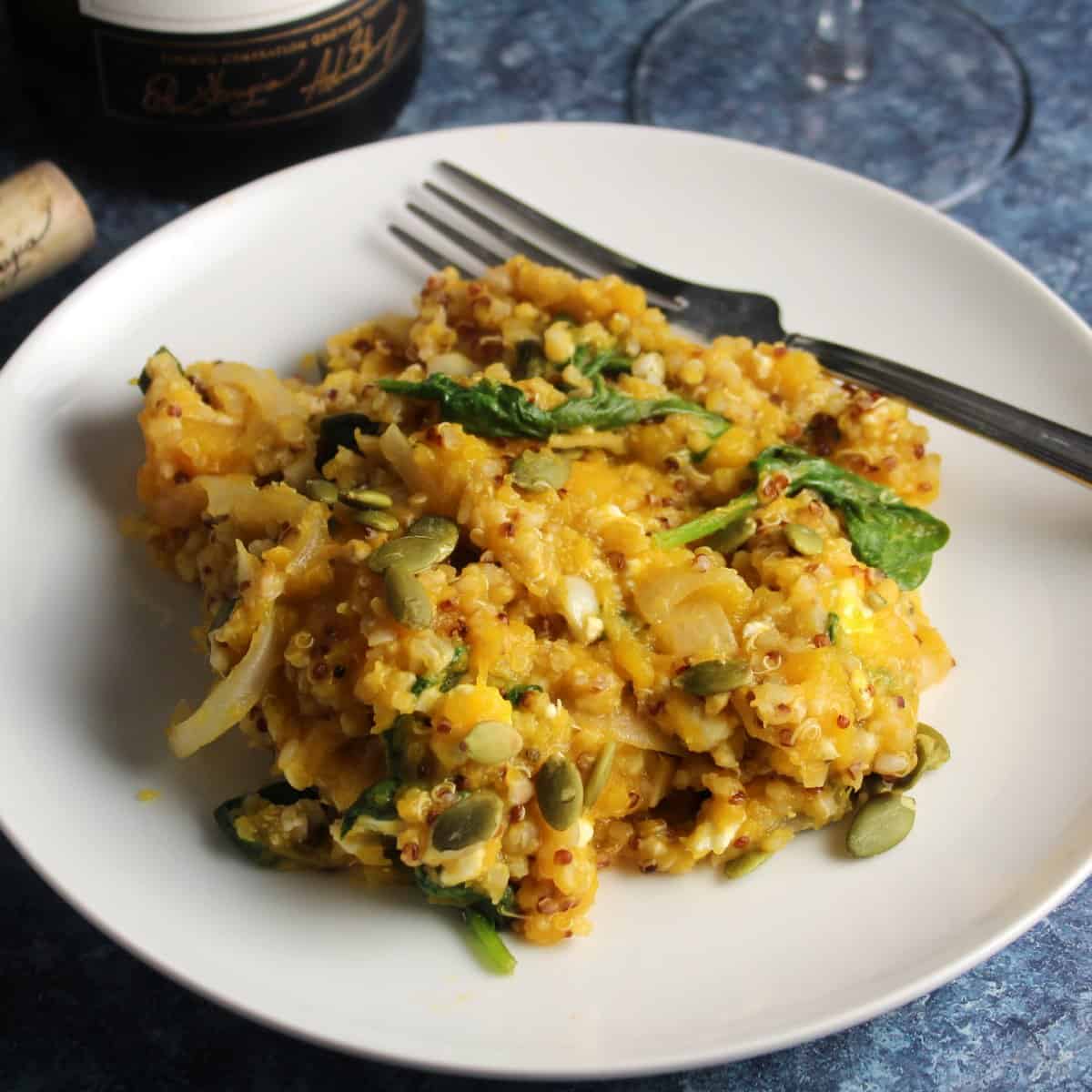 butternut squash casserole with quinoa and spinach served on a white plate