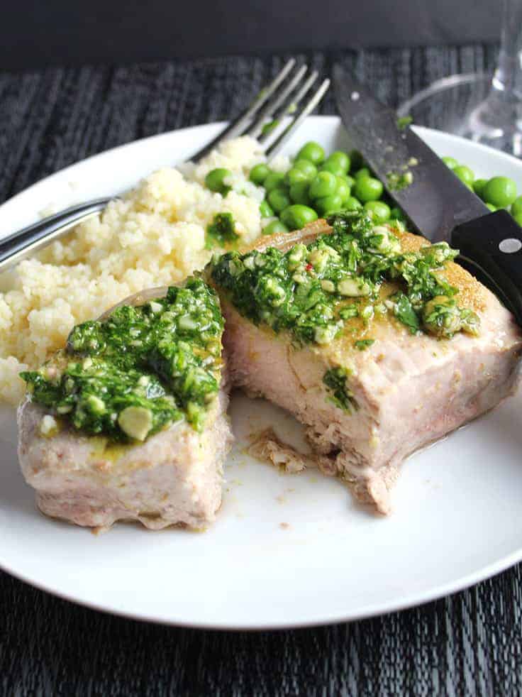 Zesty cilantro pesto tops roasted pork chops for an easy and flavorful meal.