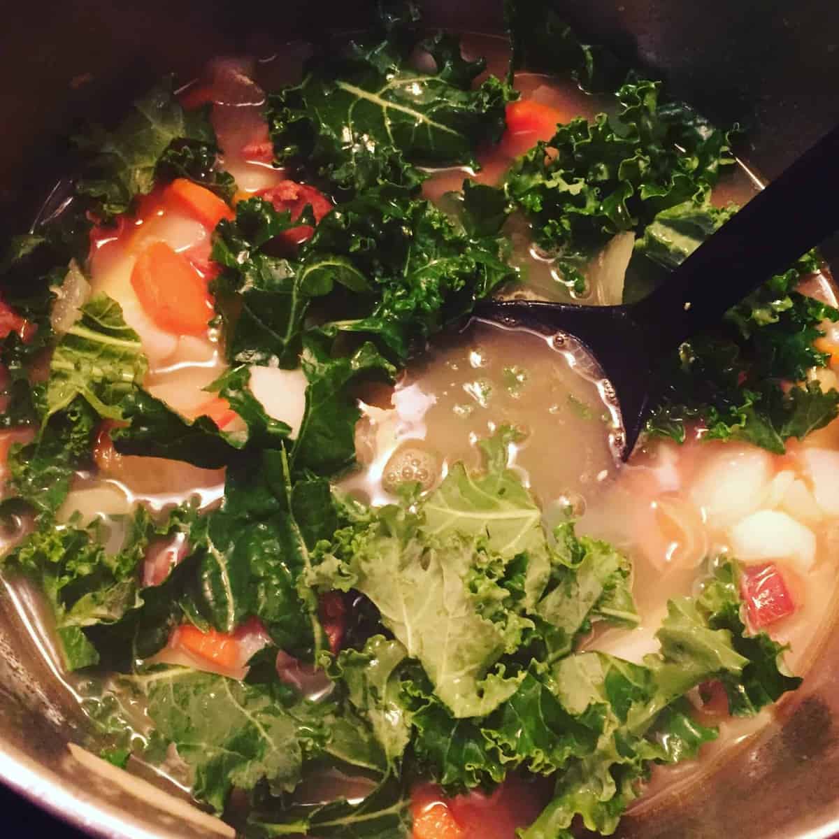 kale added to a pot of soup