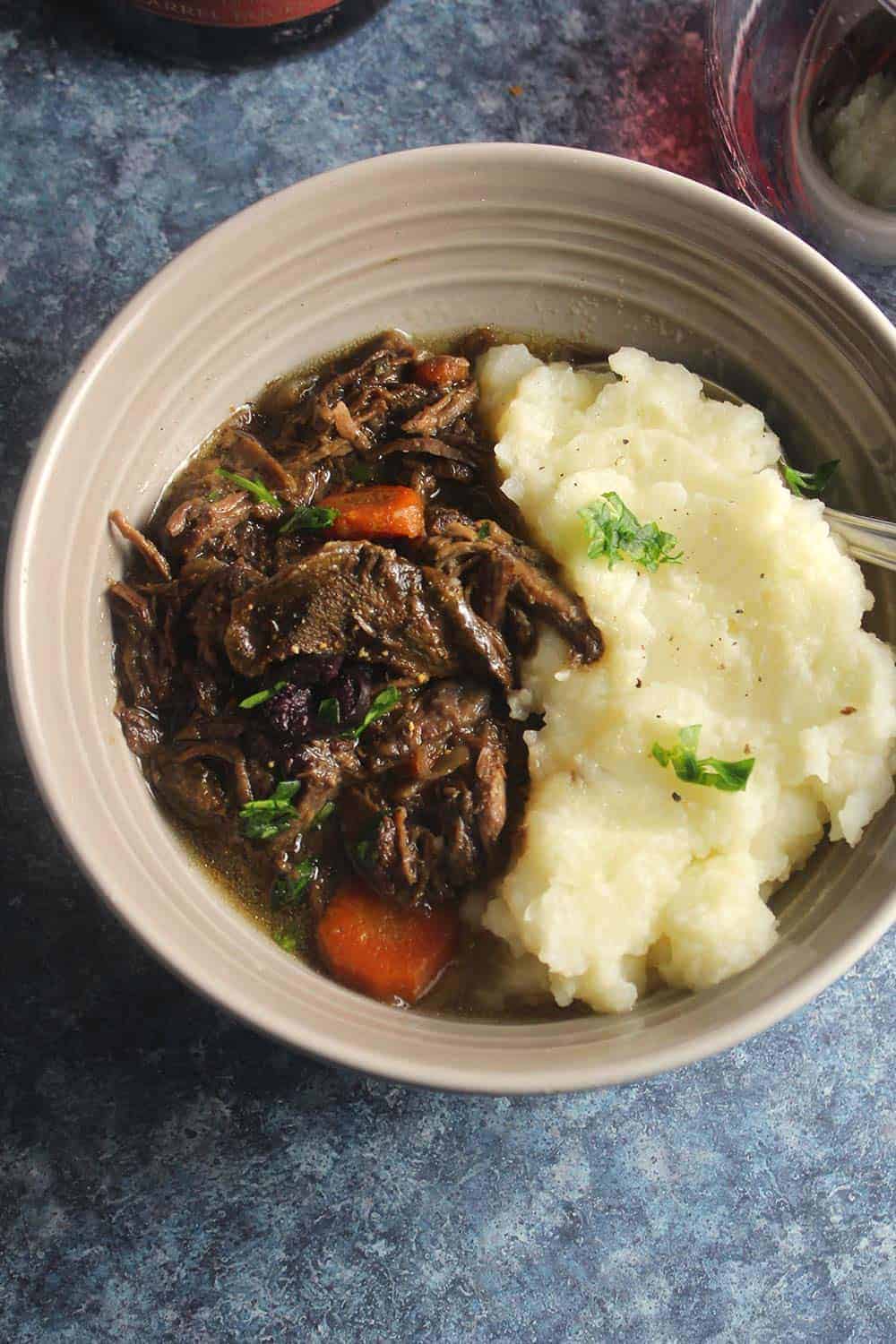 bowl of porcini beef stew with mashed potatoes.