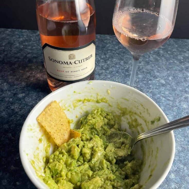 bowl of guacamole with rosé wine.