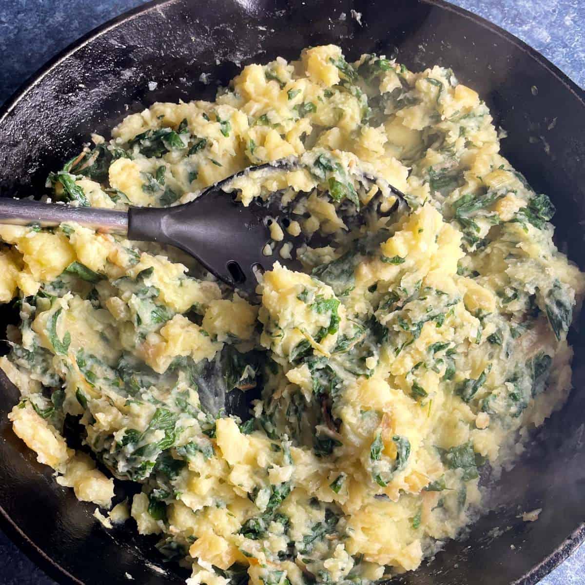 swiss chard potatoes in a black skillet.