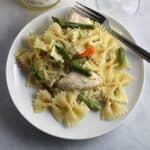bowtie pasta on a plate with asparagus and chicken.