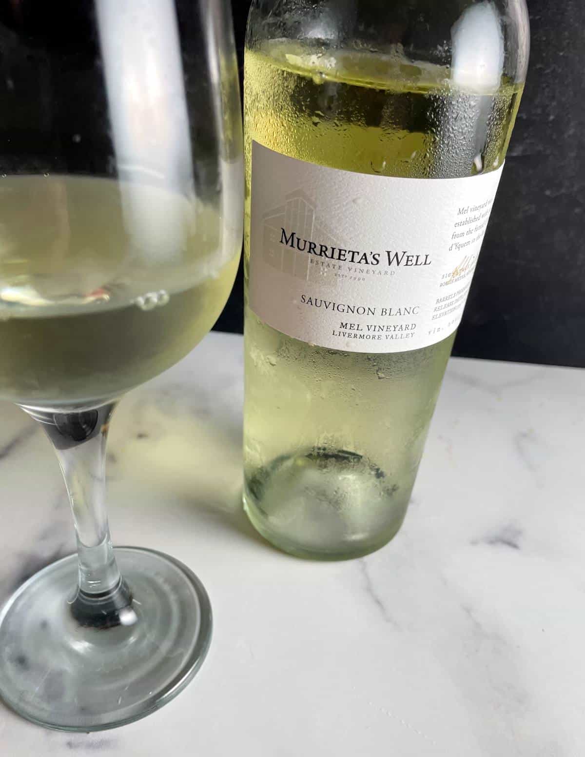 bottle of Murrieta's Well Sauvignon Blanc with a glass of the wine alongside it.