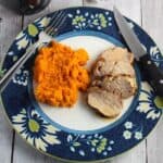 grilled pork tenderloin on a plate with sweet potatoes