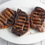 grilled ribeye steaks resting on platter.