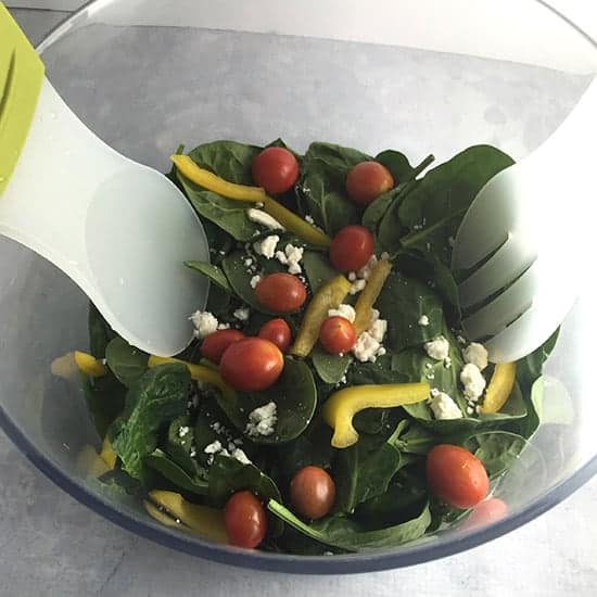 tossing spinach salad
