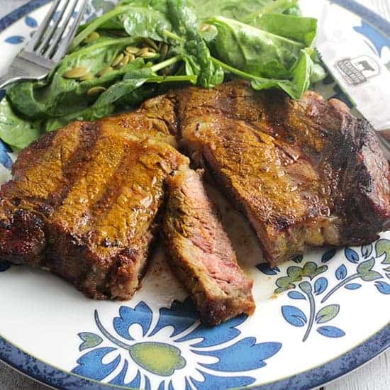 Turmeric Spiced Steak served on a plate with flowers around the edge.