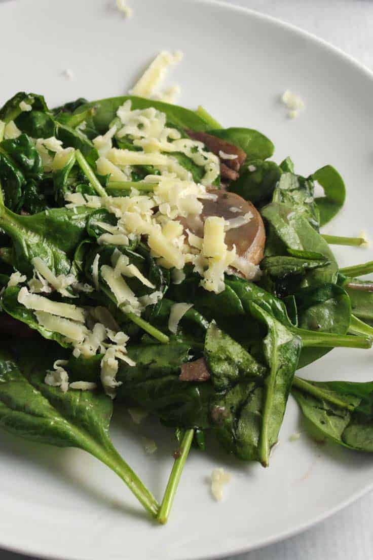 spinach sautéed with mushrooms and herbs, topped with cheddar cheese, for an easy and tasty side dish recipe.