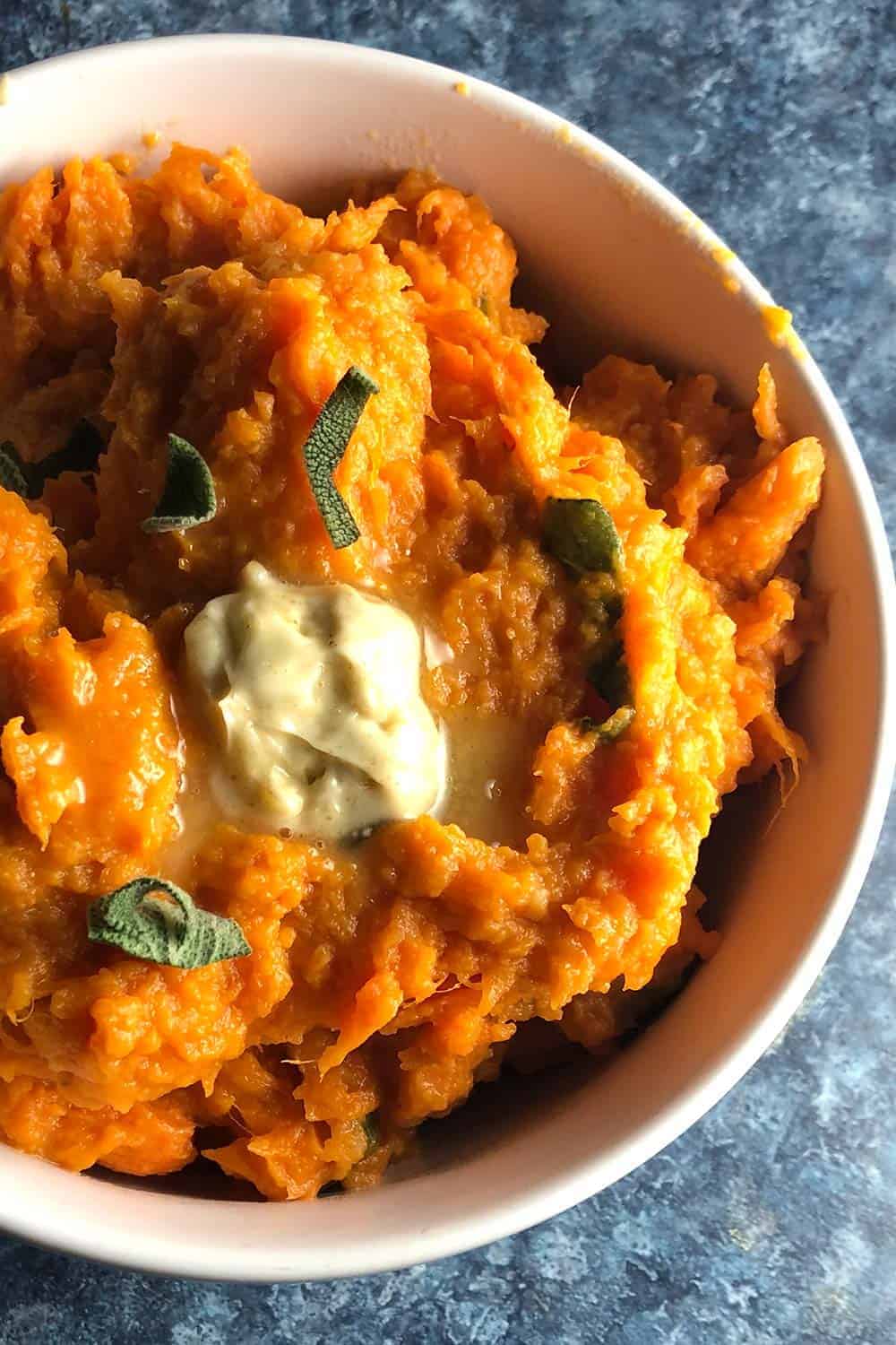 mashed sweet potatoes in a bowl with cumin sage butter.