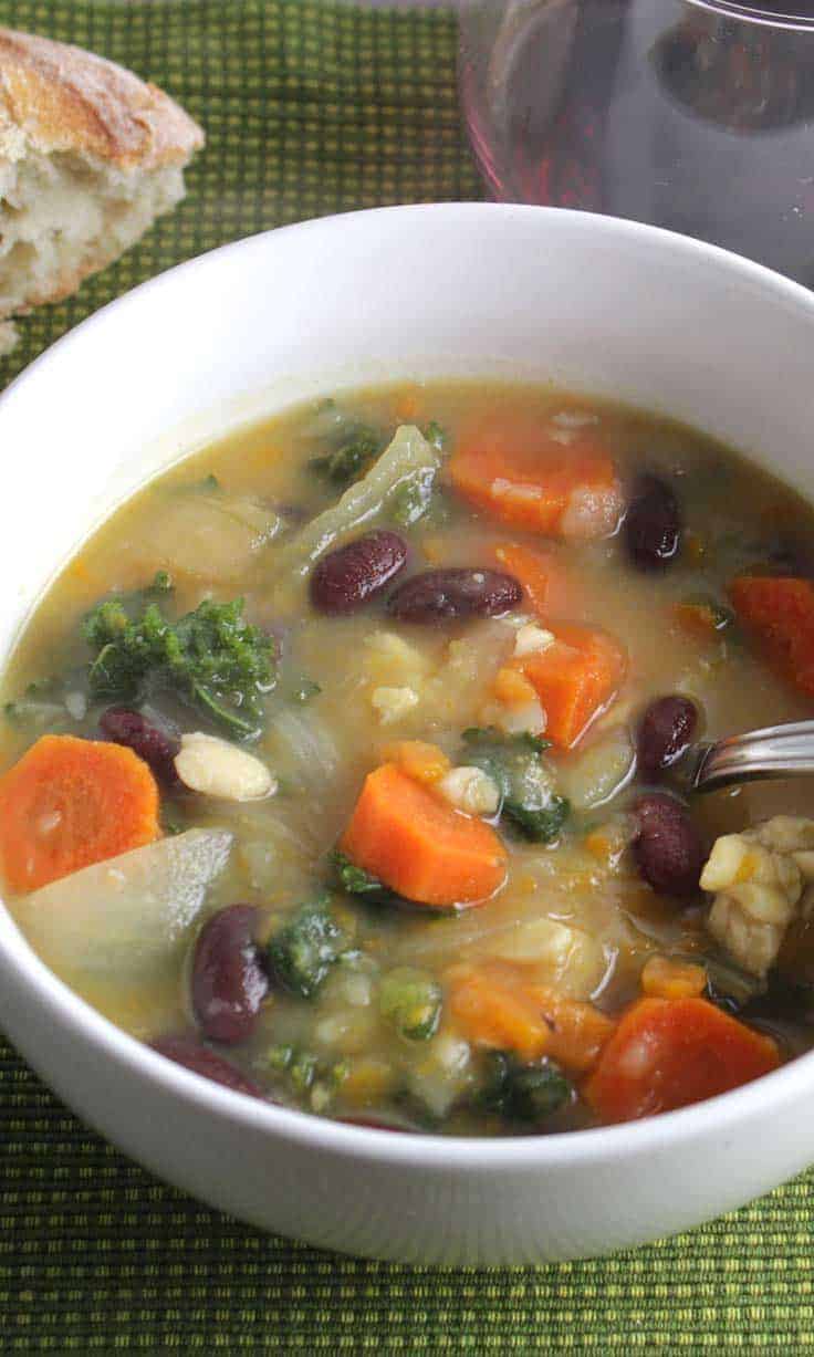 kale simmers with garlic, onions and other veggies for a flavorful, Vegetarian Kale Soup recipe. Beans and tempeh provide substance and protein.