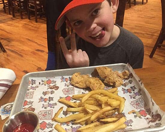 enjoying allergy safe chicken fingers at Great Wolf Lodge.