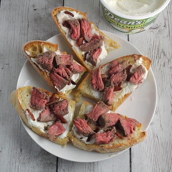 toasted crostini with onion dip topped by steak and bacon.