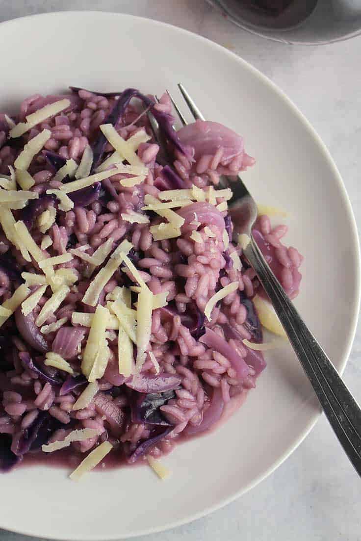 red cabbage risotto on white plate.
