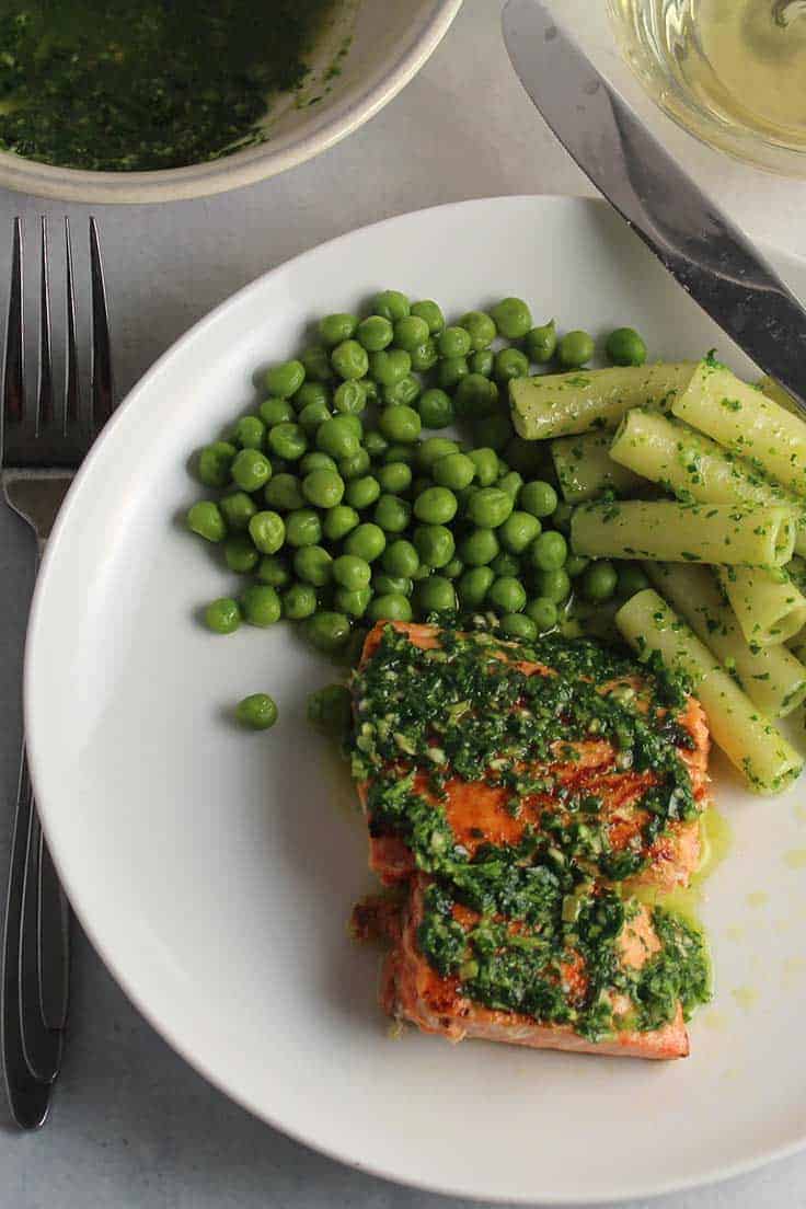 Quick pan seared salmon topped with a zesty parsley pesto for an easy and healthy dinner recipe.