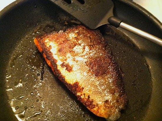 searing salmon in a pan