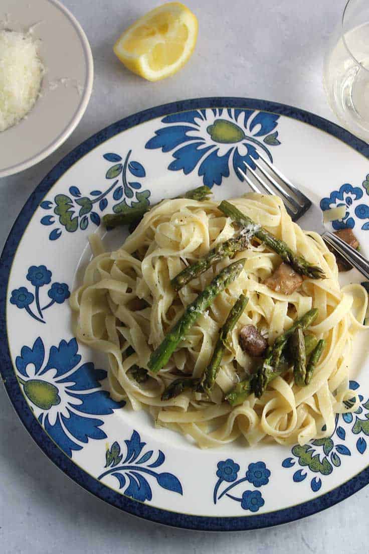 plate with roasted asparagus and mushroom fettuccine.