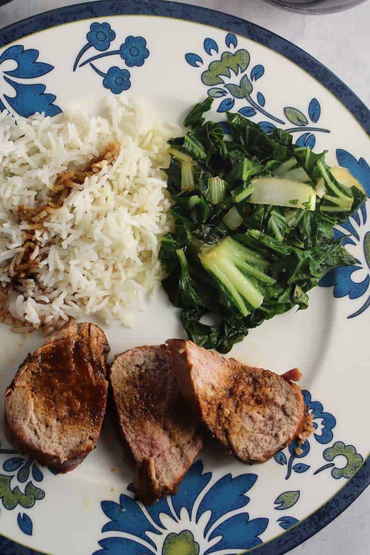 Grilled Asian Pork Tenderloin on a plate with rice and bok choy.