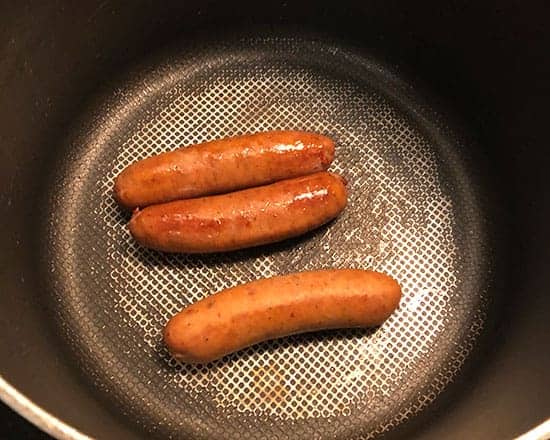 browning sausage in a soup pot