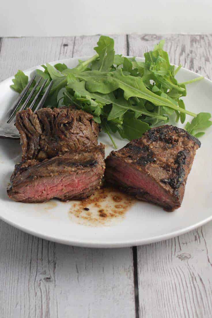 steak tips on a plate with a side of greens.