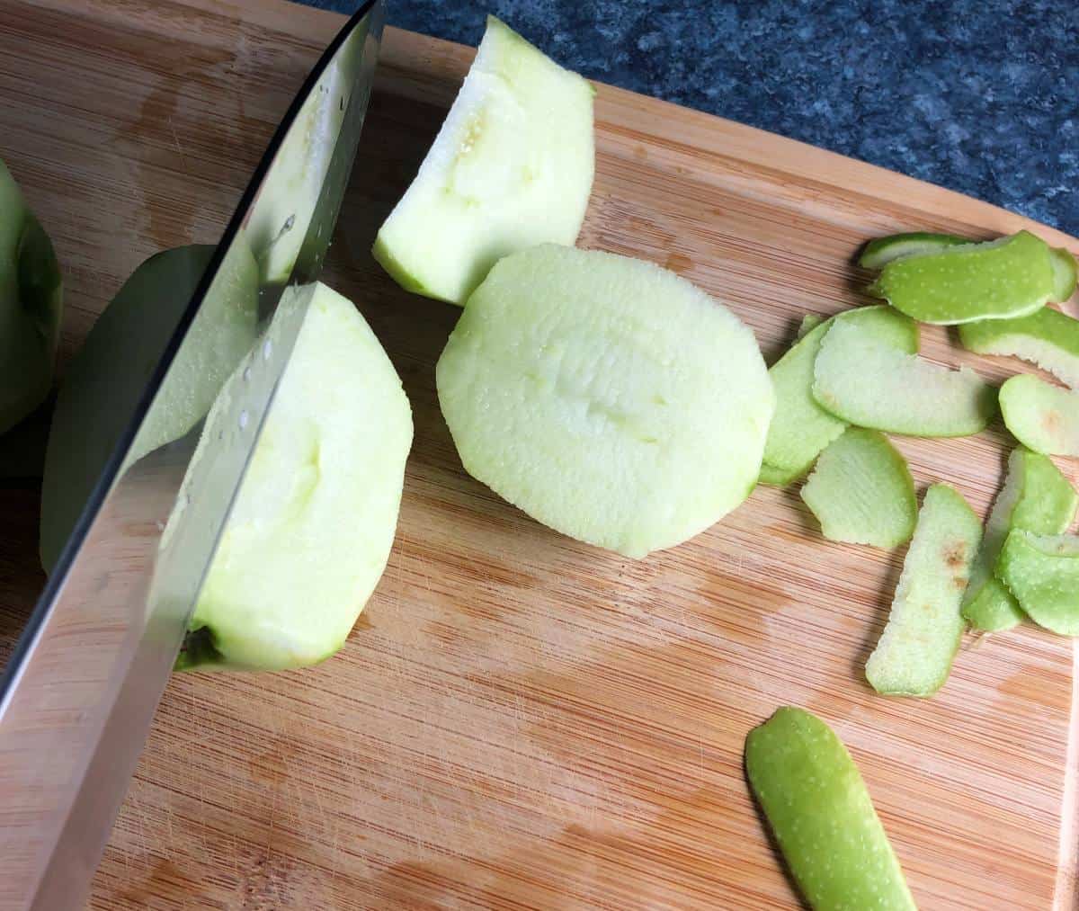 coring green apple on cutting board