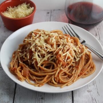 spaghetti with tomato apple pasta sauce on a white plate