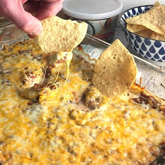 digging into some Easy Mexican Dip with a tortilla chip.