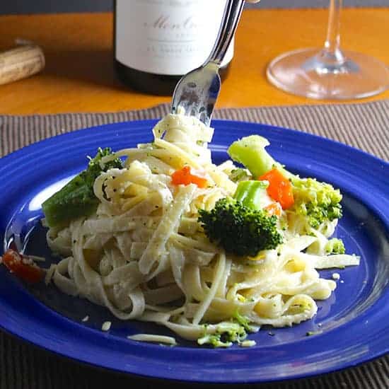 plate with fettuccine primavera being twirled with a fork.