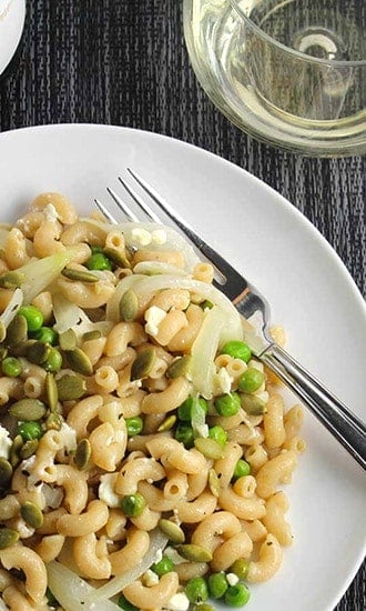 pasta with peas and feta cheese and a glass of white wine.