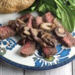 london broil steak topped with mushrooms