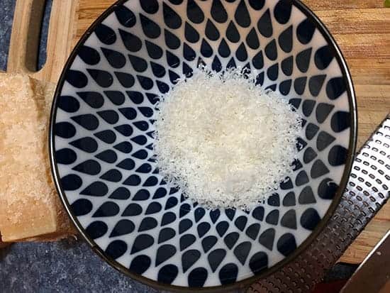grated parmesan cheese in a blue and white bowl.