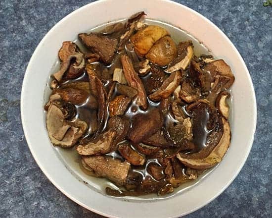 dried porcini mushrooms soaking in a bowl of warm water.