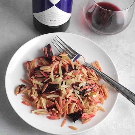 plate of roasted beet orzo served with red wine.