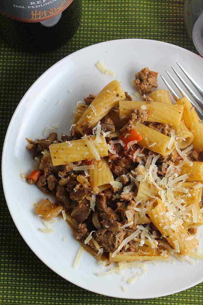 turkey Bolognese pasta with porcini mushrooms on a white plate.